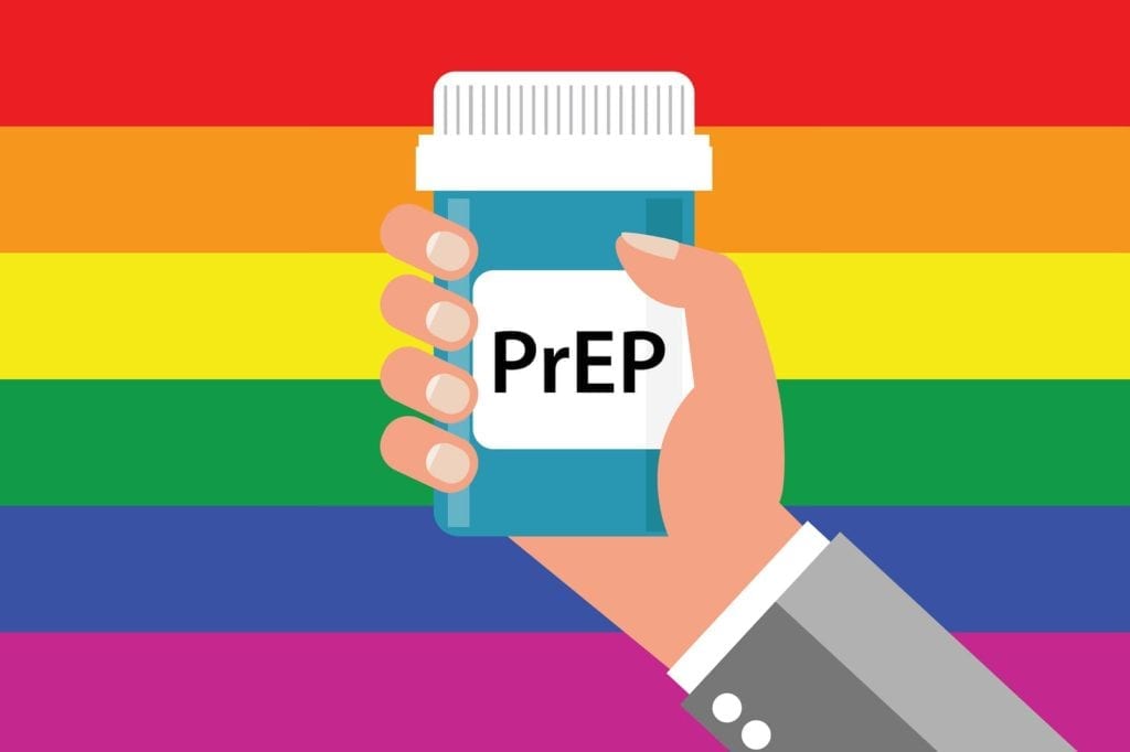 PrEP bottle being held up by a hand in front of a rainbow. 